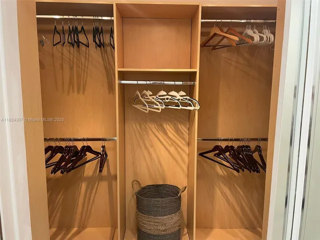 a view of walk in closet with clothes and shoes