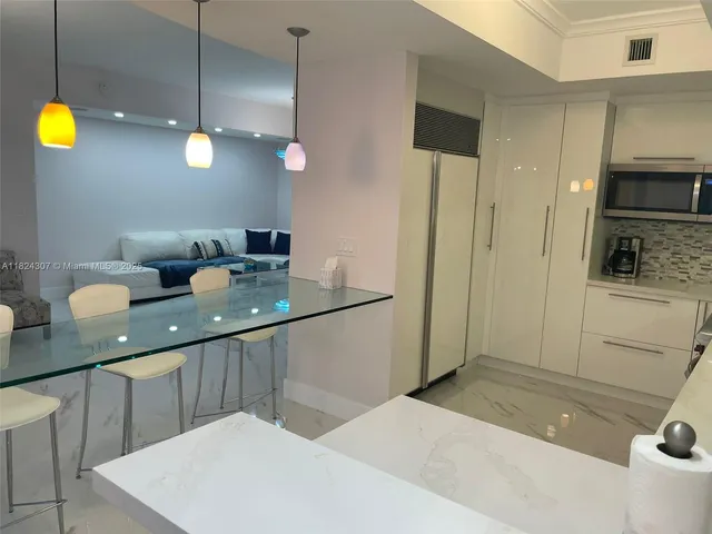 a kitchen with a sink a refrigerator and microwave