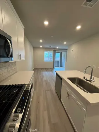 a kitchen with sink stove and cabinets
