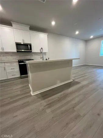 a view of kitchen with stainless steel appliances granite countertop a stove a sink and a refrigerator