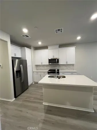 a kitchen with stainless steel appliances a refrigerator stove and microwave