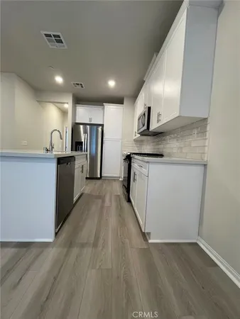 a kitchen with stainless steel appliances granite countertop a sink a stove top oven a counter space and cabinets