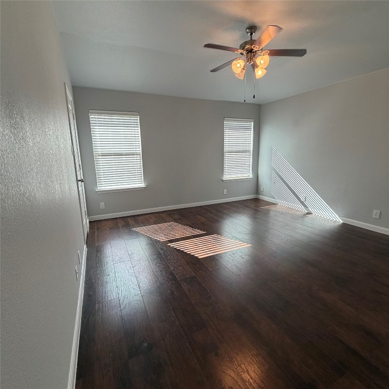 1115 Sunny Meadows Loop Georgetown, TX 78626 - Photo 15 of 36 Empty room featuring dark wood finished floors, plenty of natural light, and ceiling fan