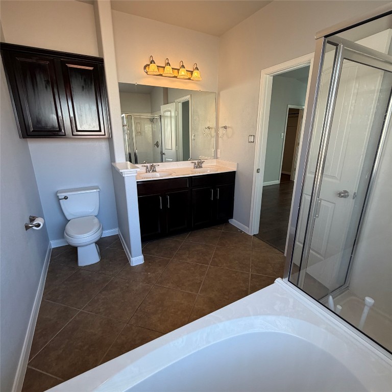 1115 Sunny Meadows Loop Georgetown, TX 78626 - Photo 18 of 36 Bathroom with a shower stall, double vanity, a bath, and dark tile patterned floors