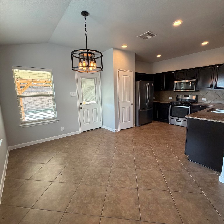 1115 Sunny Meadows Loop Georgetown, TX 78626 - Photo 24 of 36 Kitchen with a chandelier, stainless steel appliances, hanging light fixtures, tasteful backsplash, and lofted ceiling