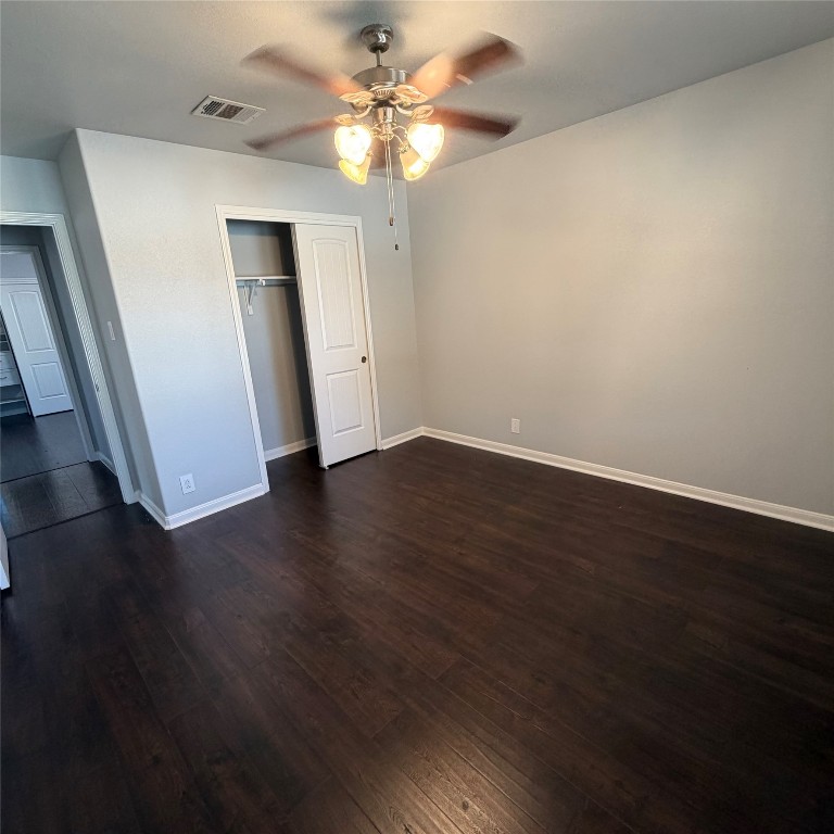 1115 Sunny Meadows Loop Georgetown, TX 78626 - Photo 6 of 36 Unfurnished bedroom with dark wood-type flooring, ceiling fan, and a closet