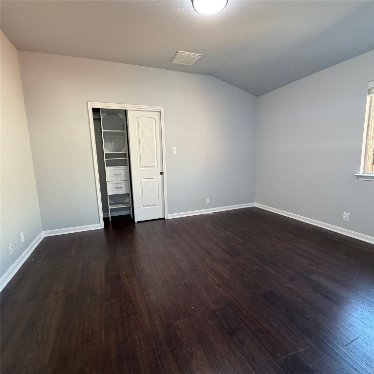 1115 Sunny Meadows Loop Georgetown, TX 78626 - Photo 9 of 36 Unfurnished bedroom featuring a closet, dark wood-style floors, and vaulted ceiling
