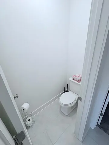 a white toilet sitting next to a sink and vanity
