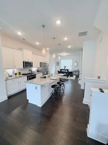 a kitchen with stainless steel appliances kitchen island sink stove refrigerator and cabinets