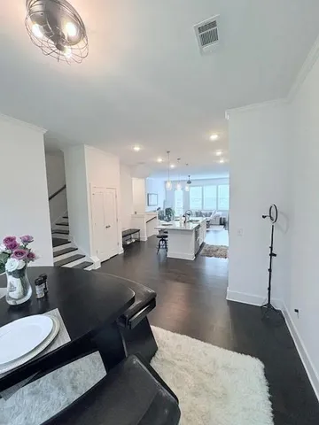 a living room with couches and kitchen view with wooden floor