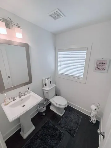a bathroom with a sink toilet and mirror