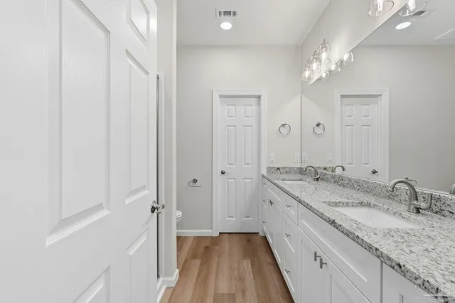 a spacious bathroom with a granite countertop sink a mirror and a shower