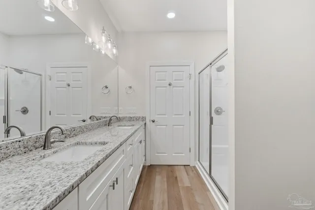 a bathroom with a granite countertop sink a large mirror and a shower