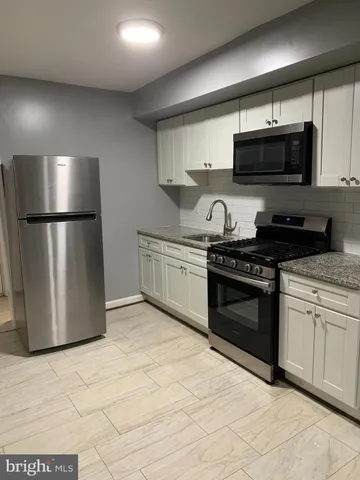 a kitchen with stainless steel appliances granite countertop a stove a refrigerator and a microwave