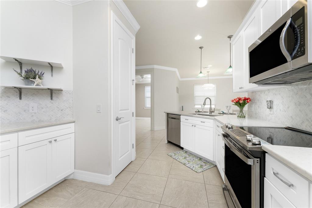 13869 Alafaya Street Venice, FL 34293 - Photo 12 of 75 a kitchen with stainless steel appliances granite countertop a stove a sink and a microwave