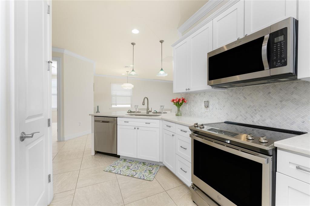 13869 Alafaya Street Venice, FL 34293 - Photo 15 of 75 a kitchen with stainless steel appliances a sink dishwasher stove and microwave