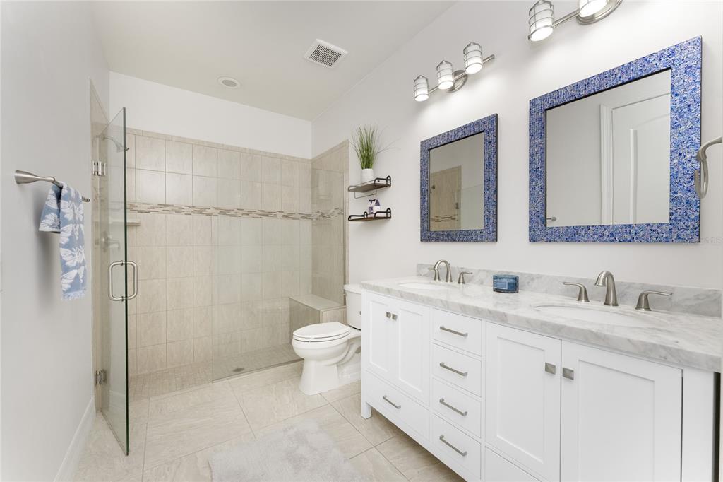 13869 Alafaya Street Venice, FL 34293 - Photo 30 of 75 a bathroom with a double vanity sink mirror and toilet