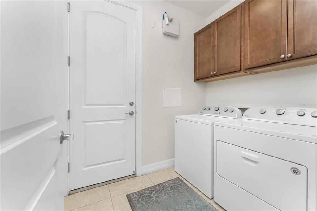 13869 Alafaya Street Venice, FL 34293 - Photo 35 of 75 a utility room with cabinets washer and dryer