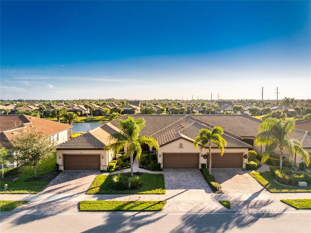 13869 Alafaya Street Venice, FL 34293 - Photo 49 of 75 an aerial view of a house with swimming pool and lake view