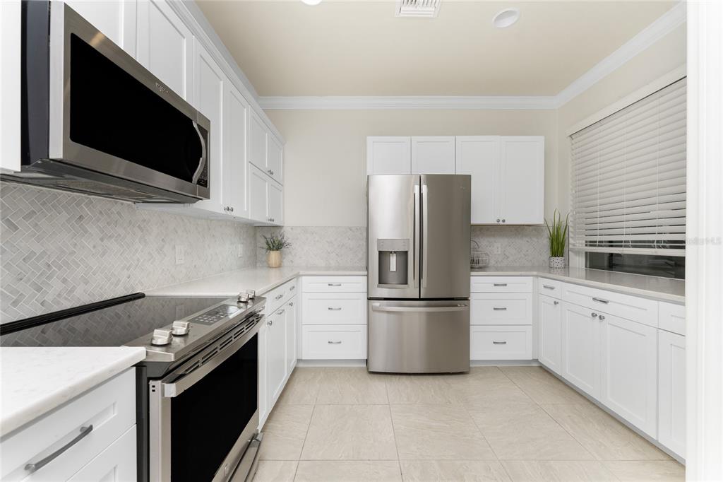 13869 Alafaya Street Venice, FL 34293 - Photo 6 of 75 a kitchen with stainless steel appliances and white cabinets