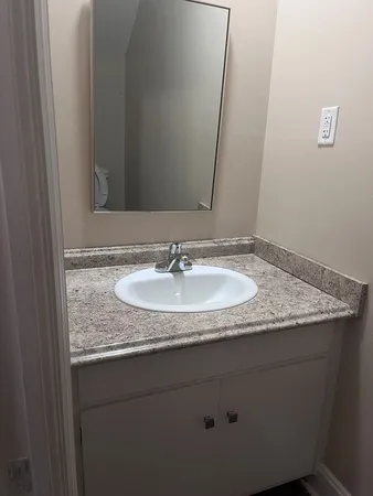 a white toilet sitting next to a small white wall