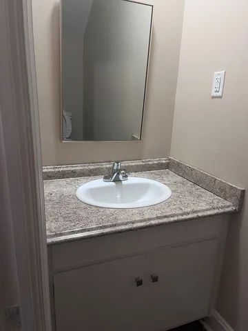 a white toilet sitting next to a small white wall