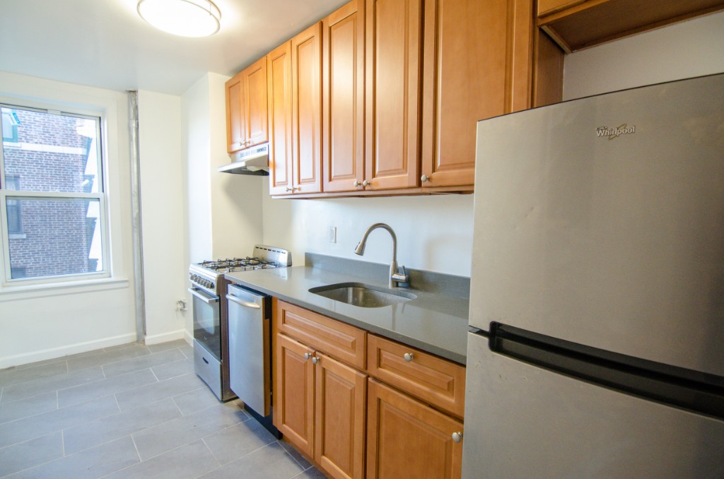 a kitchen with stainless steel appliances granite countertop a sink and a window