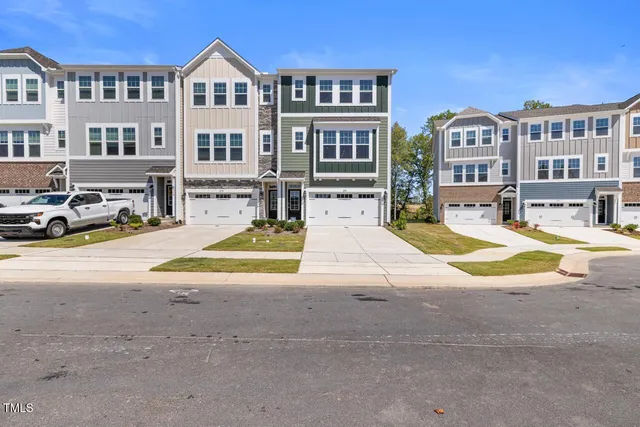 a view of residential houses with cars parked infront