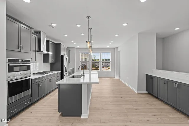 a large kitchen with stainless steel appliances lots of counter space and a sink