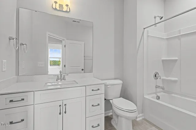 a bathroom with a toilet sink vanity tub and shower