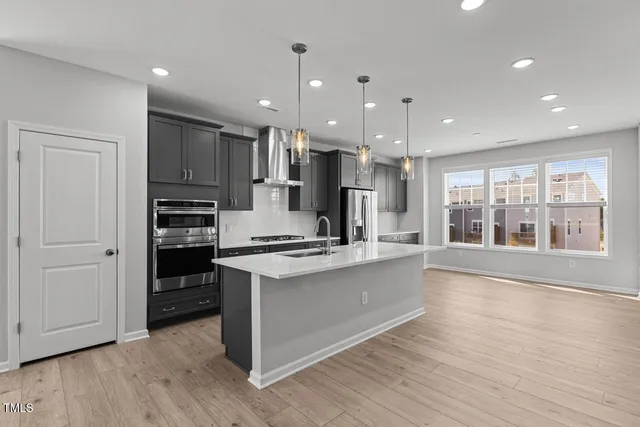 a large kitchen with stainless steel appliances granite countertop a stove and a refrigerator