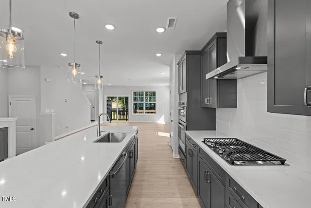 a large kitchen with stainless steel appliances a large counter top a stove and a refrigerator