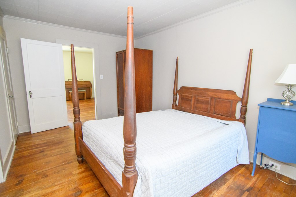 24432 Maxwell Street Parksley, VA 23421 - Photo 19 of 39 a bedroom with a bed and wooden floor