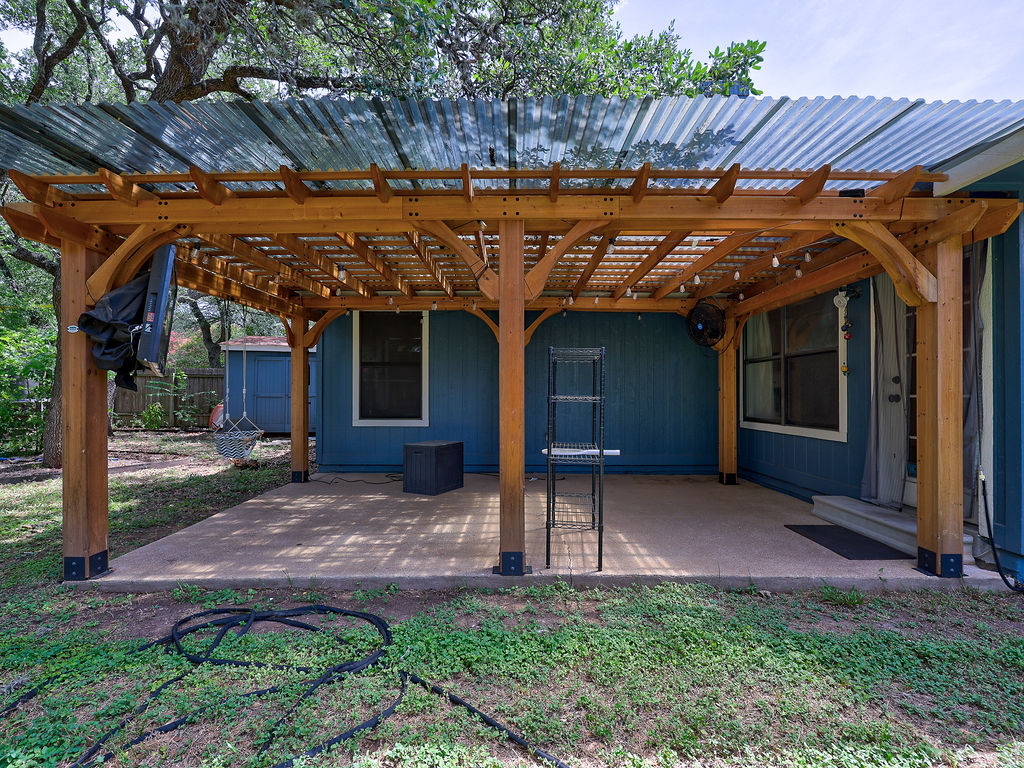 5842 Secrest Drive Austin, TX 78759 - Photo 26 of 40 A spacious concrete patio provides ample outdoor living space, sheltered by a handsome wooden pergola.
