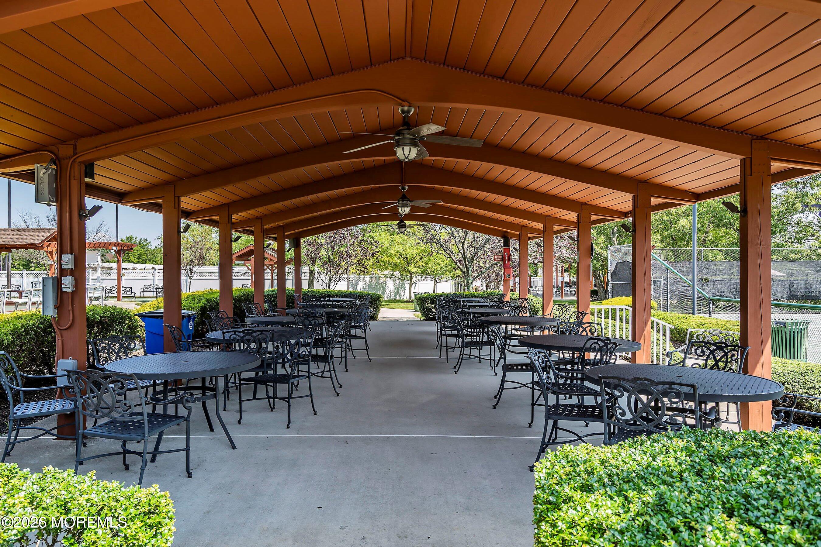 10 Arcadia Drive Manchester Township, NJ 08759 - Photo 29 of 37 a view of a patio with table and chairs potted plants and palm tree