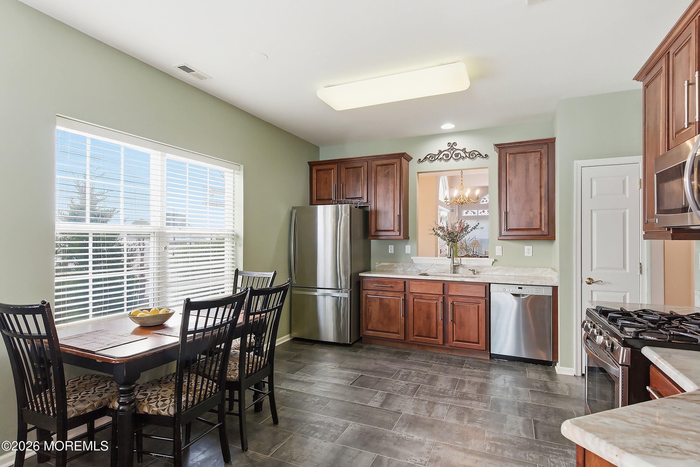 10 Arcadia Drive Manchester Township, NJ 08759 - Photo 7 of 37 a kitchen with refrigerator a stove a dining table and chairs