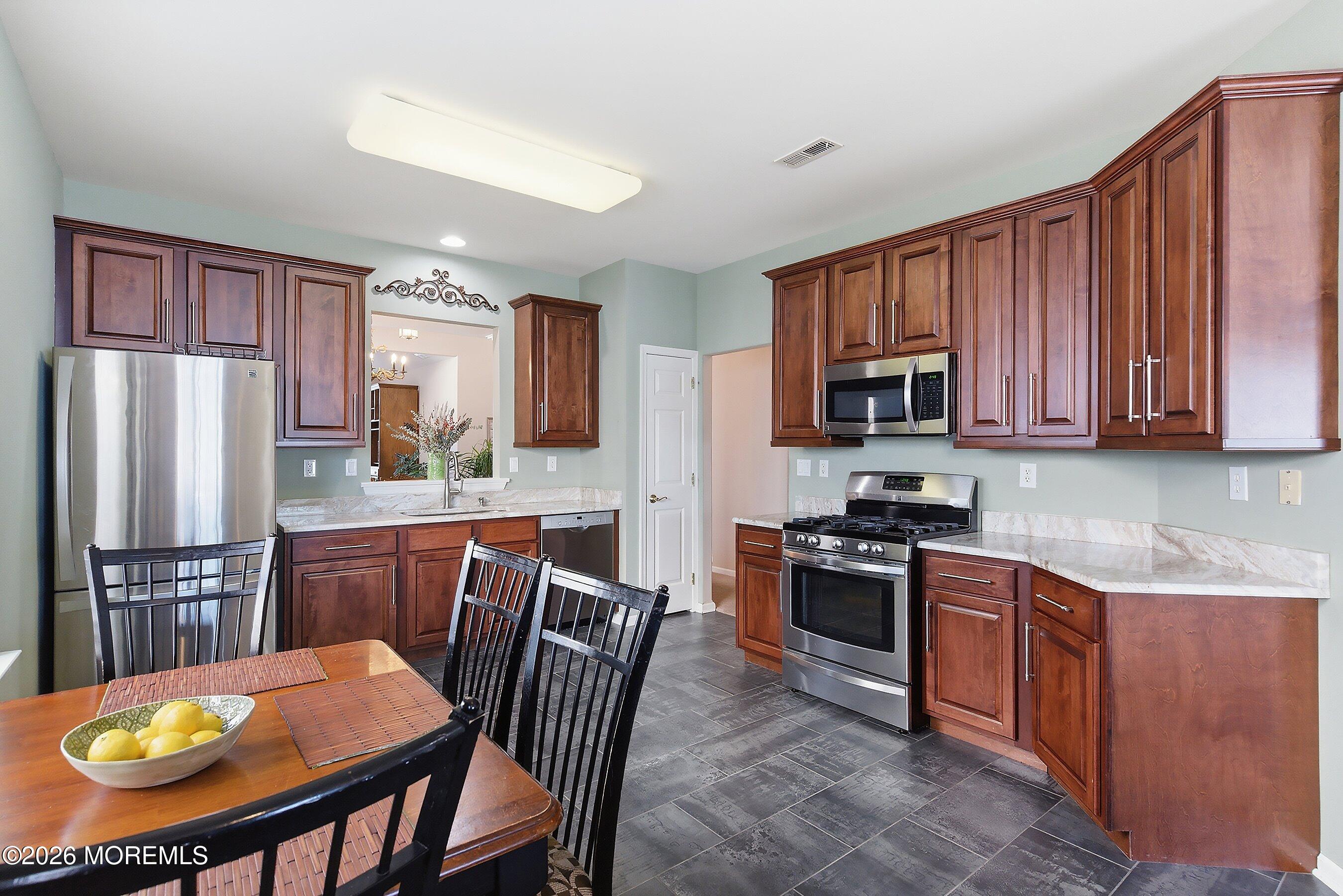 10 Arcadia Drive Manchester Township, NJ 08759 - Photo 8 of 37 a kitchen with stainless steel appliances granite countertop a stove a refrigerator a sink dishwasher and wooden cabinets with wooden floor