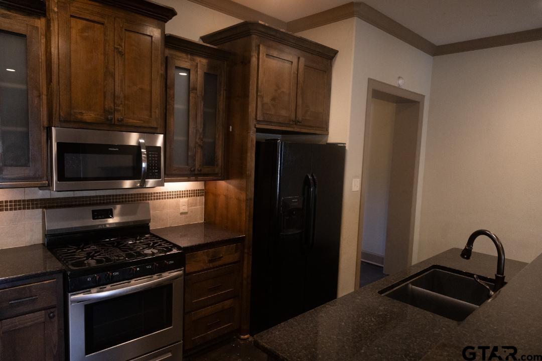 300 Rita Drive Lindale, TX 75771 - Photo 3 of 17 a kitchen with granite countertop a refrigerator stove and microwave