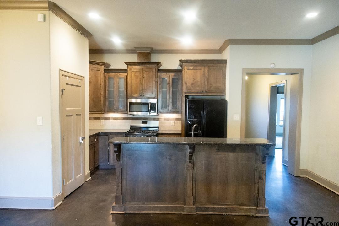 300 Rita Drive Lindale, TX 75771 - Photo 4 of 17 a kitchen with stainless steel appliances granite countertop a refrigerator and a stove