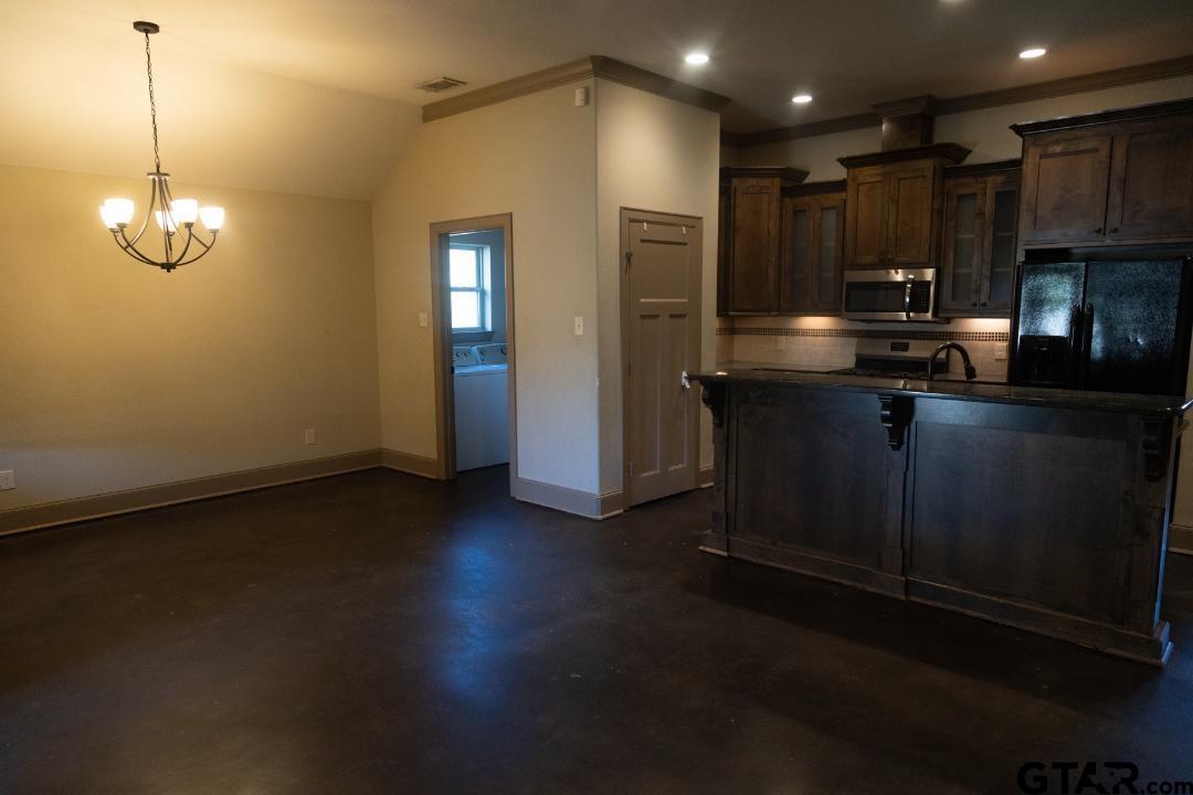 300 Rita Drive Lindale, TX 75771 - Photo 6 of 17 a kitchen with stainless steel appliances granite countertop a refrigerator a sink dishwasher a stove and a microwave oven on granite countertops