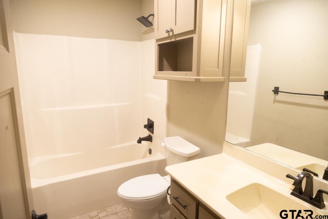 300 Rita Drive Lindale, TX 75771 - Photo 8 of 17 a bathroom with a sink a toilet and bathtub