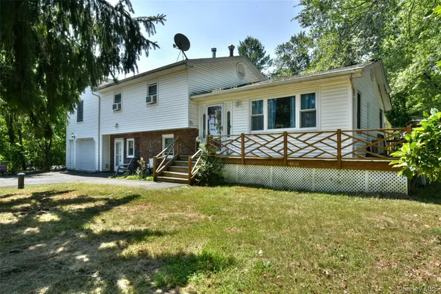 a view of a house with backyard and sitting area