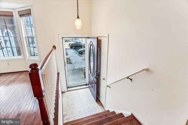 a view of a livingroom with wooden floor and stairs