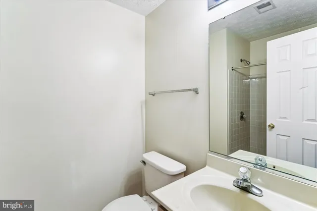 a bathroom with a sink and mirror with toilet