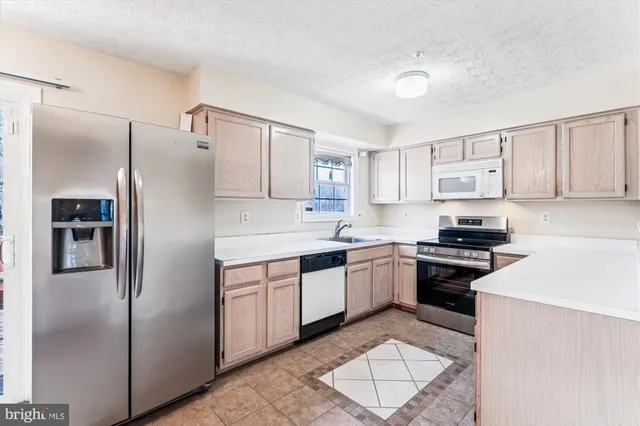 a kitchen with stainless steel appliances granite countertop a stove a refrigerator and a sink