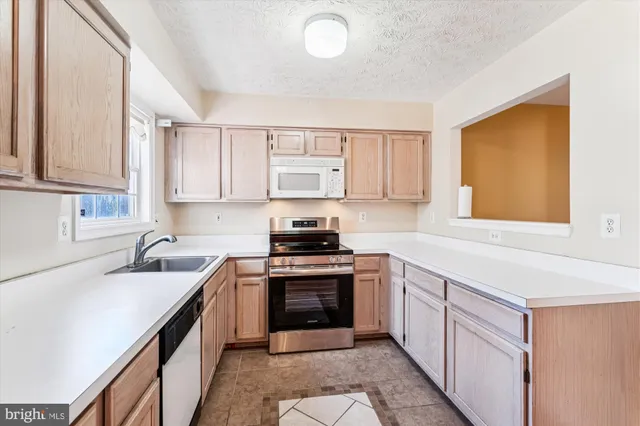 a kitchen with stainless steel appliances a sink and a refrigerator
