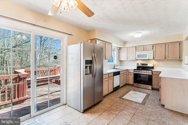 a kitchen with stainless steel appliances granite countertop a refrigerator and a stove