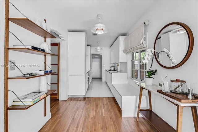 a view of a living room and bathroom with wooden floor