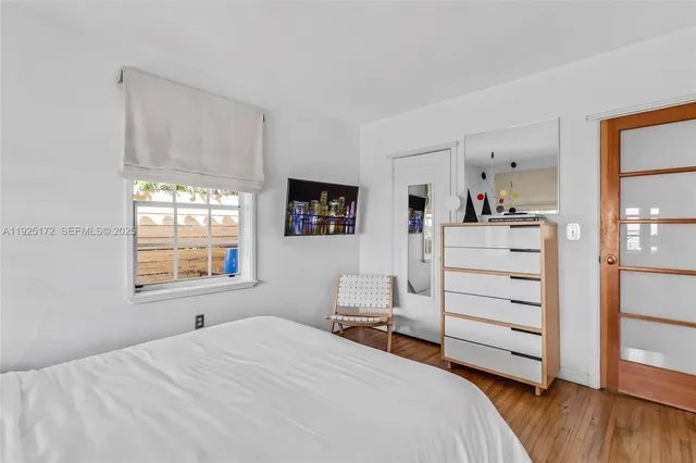 a bedroom with a bed and wooden floor