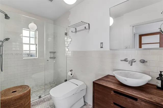 a bathroom with a granite countertop sink a toilet and a mirror